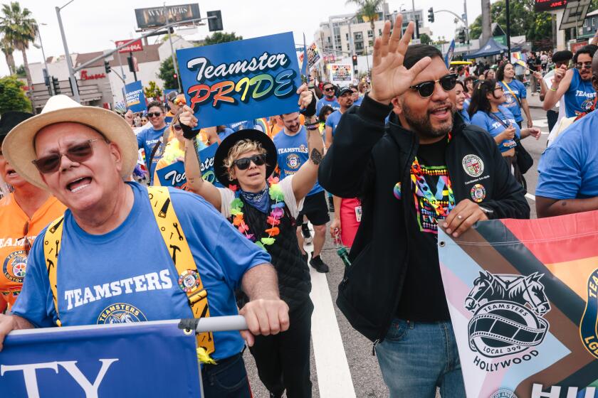 Los Angeles, CA - June 09: People walk along with the Teamsters Local 399 float during the Los Angeles Pride Parade on Sunday, June 9, 2024 in Los Angeles, CA. Teamsters Local 399 is the labor union representing Hollywood drivers, animal trainers, location scouts and other crew members (Dania Maxwell / Los Angeles Times)