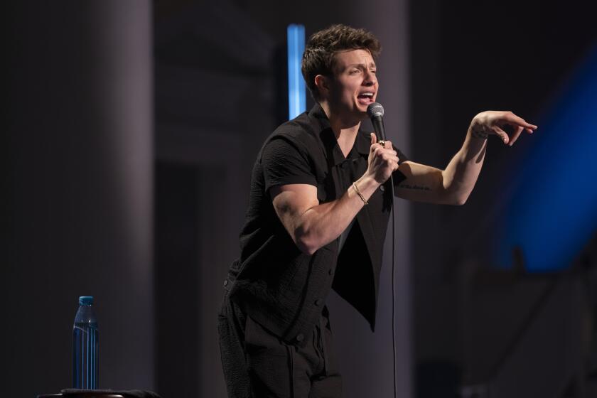 Man standing on stage pointing a finger at an audience