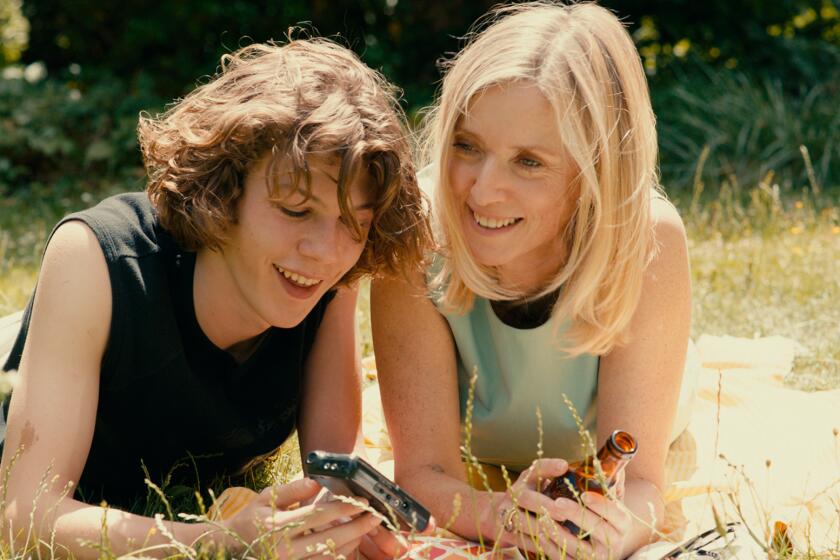 A woman and her stepson lay on the grass.