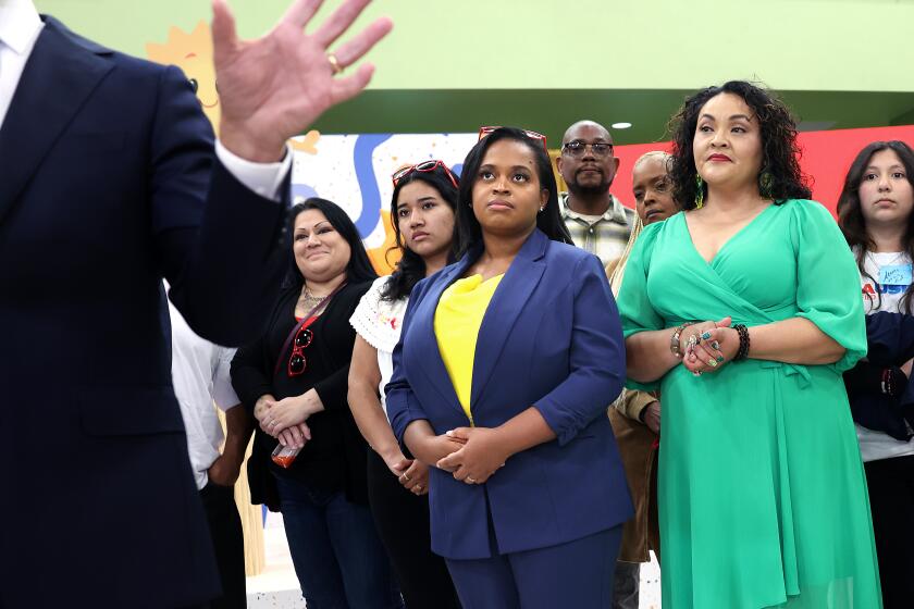 LOS ANGELES-CA-MARCH 20, 2024: Joanna Smith-Griffin, in center wearing blue suit, Founder and then-CEO of AllHere Education, the company that co-created "Ed," the artificial intelligence chat bot for the Los Angeles Unified School District, listens as Los Angeles Unified Supt. Alberto Carvalho, left, speaks to reporters during the official launch of Ed, at Edward R. Roybal Learning Center in Los Angeles on March 20, 2024. (Christina House / Los Angeles Times)