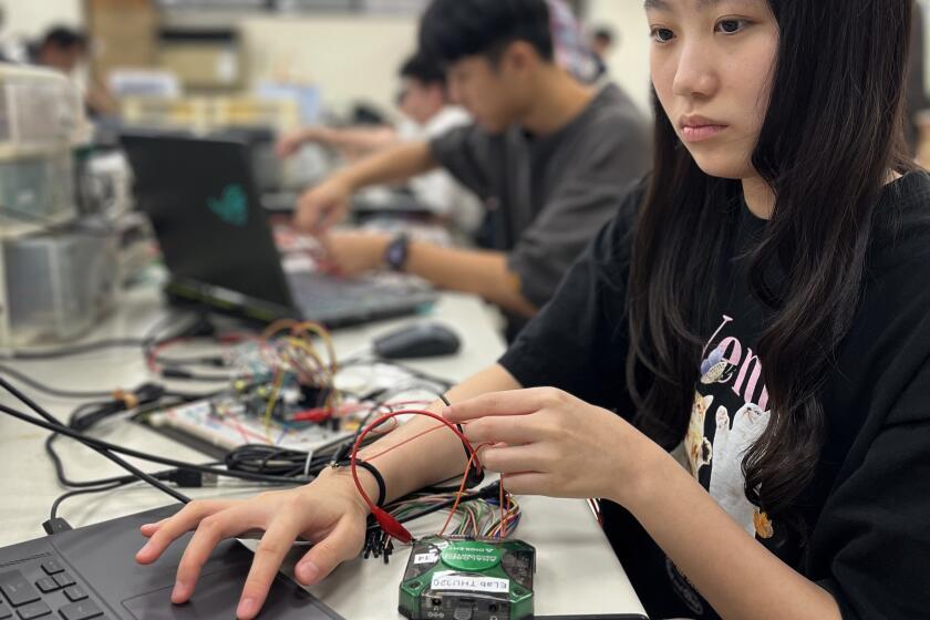 Wei Yu-han, 19, works on her final project in the electronics engineering lab at NYCU (Stephanie Yang / Los Angeles Times)