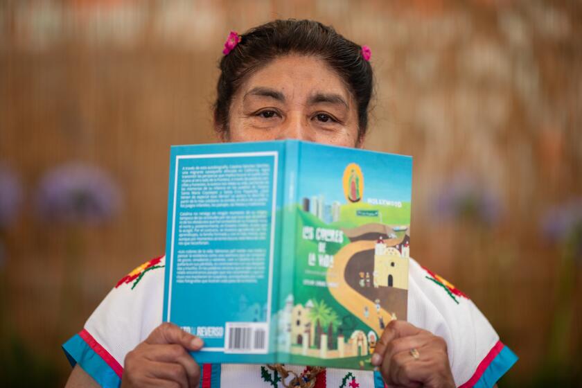 Los Angeles, CA - July 02: Catalina Sanchez with her new book is photographed at Guelaguetza Restaurant on Tuesday, July 2, 2024 in Los Angeles, CA. (Ringo Chiu / For Los Angeles Times en Espanol)