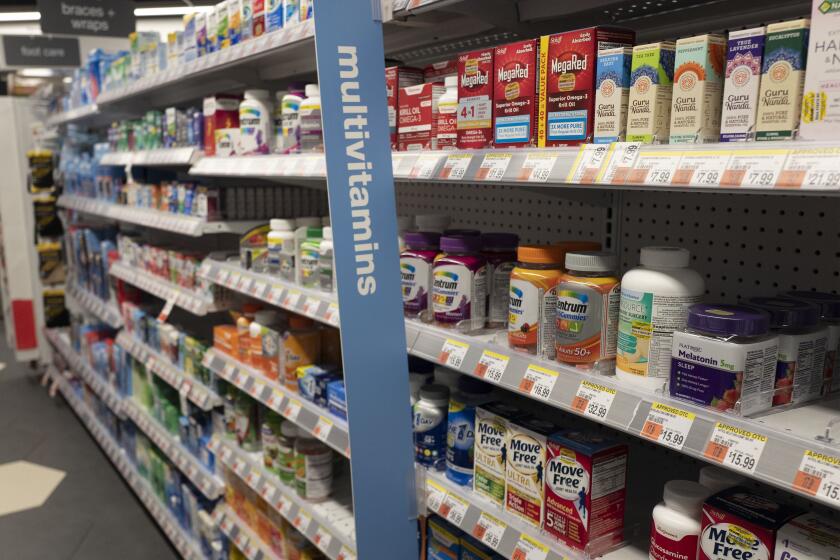 Vitamins are displayed in pharmacy Duane Reade by Walgreens, Thursday, March 25, 2021, in New York. Walgreens reports earnings March 31, 2021. (AP Photo/Mark Lennihan)