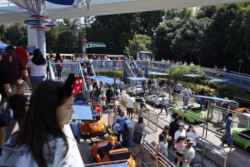 Anaheim, CA - March 11: Visitors at Autopia in Tomorrowland at Disneyland. Environmental activists Zan Dubin and Paul Scott, not shown, recently filed a complaint about air pollution and noxious smells from Autopia with Southern California air quality regulators at Disneyland in Anaheim Monday, March 11, 2024. They want Disneyland to convert Autopia to electric vehicles, and to find other ways -in Tomorrowland and across the park - to bring clean energy into its storytelling. (Allen J. Schaben / Los Angeles Times)