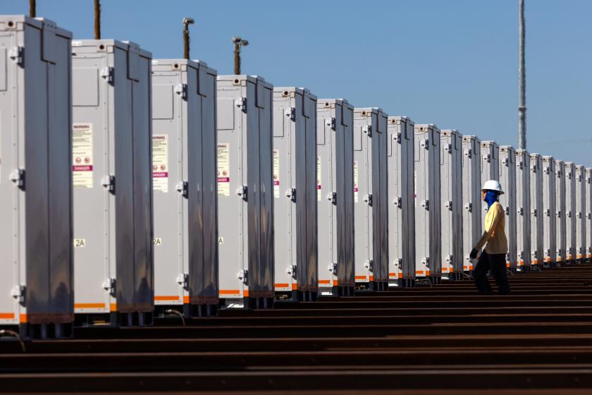 DAGGETT, CA - OCTOBER 18: Rafael Carvajal Jr., 18, a Wartsila technician checks equipment installed at Clearway Daggett 3 Solar Power + Battery Energy Storage System on Wednesday, Oct. 18, 2023 in Daggett, CA. (Irfan Khan / Los Angeles Times)