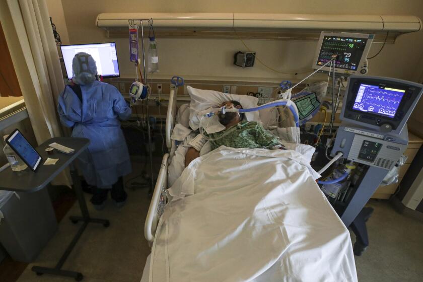 Fullerton, CA - February 15: Nurse Celina Mande attends to coronavirus patient Joseph Trejo who is on ventilator. Patty Trejo arranged a mariachi band plays "La mano de Dios" (The Hand of God), the favorite song of her husband Joseph Trejo who is on ventilator at St. Jude Medical Center on Monday, Feb. 15, 2021 in Fullerton, CA.(Irfan Khan / Los Angeles Times)