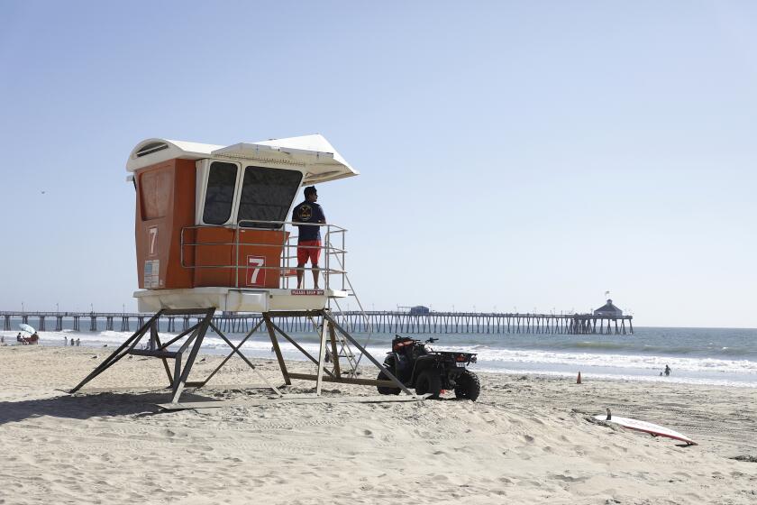 IMPERIAL BEACH CA AUGUST 2, 2023 -Imperial Beach Lifeguard 1 Juan Davila on Tower Seven looks west with the Imperial Beach Pier in sight during his shift. The Imperial Beach City Council met at 6 p.m. Wednesday night and did not renew a moratorium on new gun dealers in the city, allowing Stephanie Gilreath to open her business, Outdoor Woman, LLC, a women's sporting goods business. Gilreath said about 10 percent of her business would include selling firearms. A moratorium was imposed last month in response to her proposal of opening the only store in town that would sell firearms. These kinds of debates are playing out in cities across California, from Burbank, Culver City and Torrance in L.A. to Redwood City in the Bay Area. (John Gastaldo / For The Times)