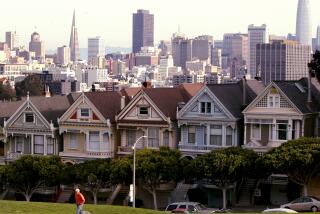 San Francisco, CA - A visitor walks through Alamo Square near ornate houses overlooking downtown San Francisco on a recent morning. Steeped in history, culture and financial and natural wealth, San Francisco attracts millions of visitors annually. However, the city by the bay now has a dubious reputation for intractable homelessness, rampant crime and an exodus of business. (Luis Sinco / Los Angeles Times)