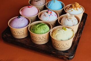 Nine small cups of Awan ice cream in various flavors against a rust-colored background.